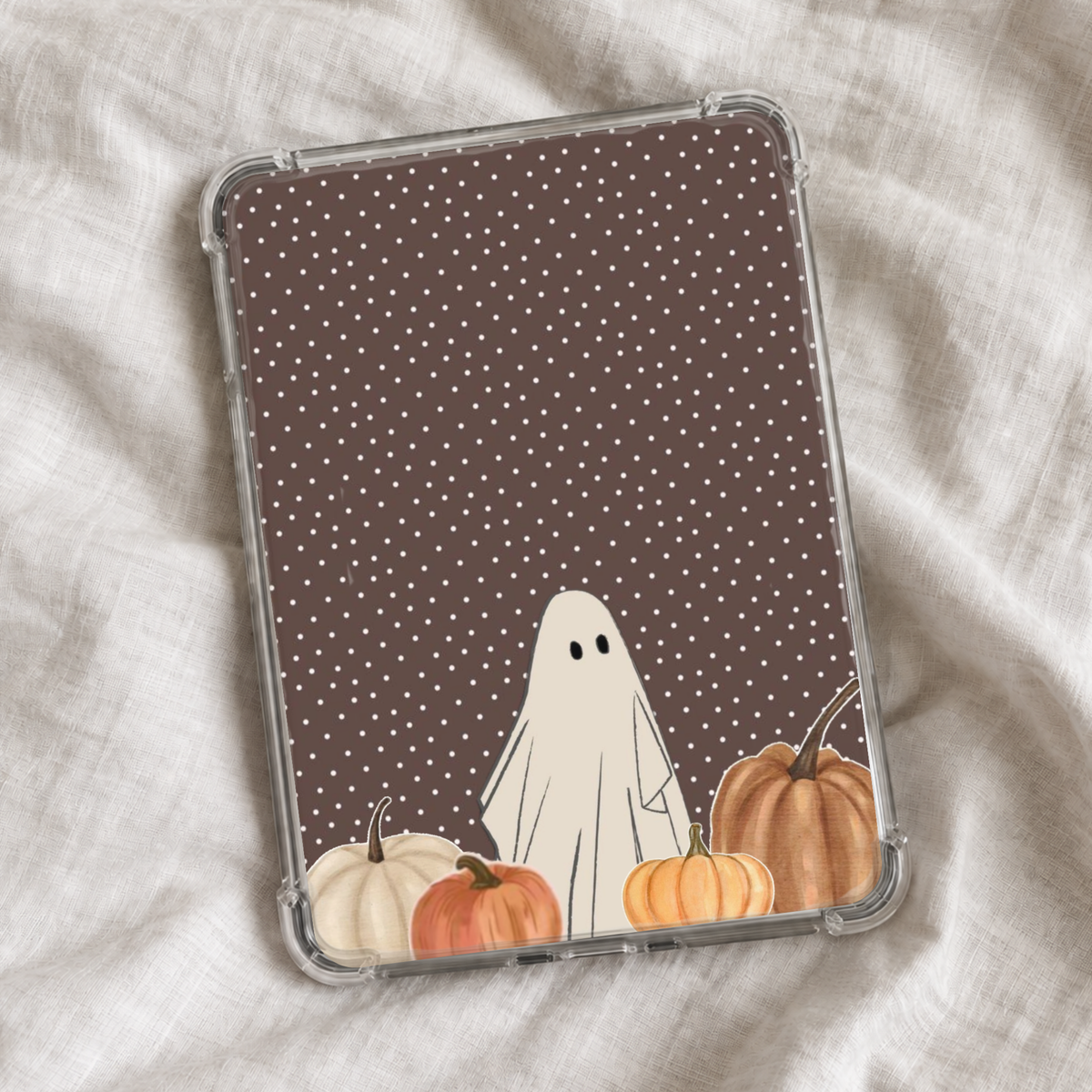 Minimal Halloween Kindle insert featuring a cute cream ghost surrounded by watercolor pumpkins on a chocolate brown background with tiny white polka dots.