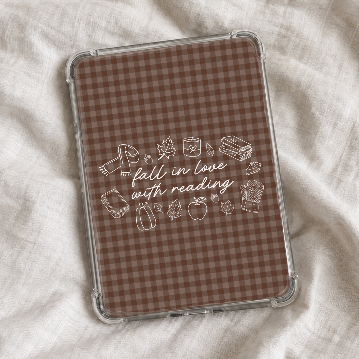 Fall-themed Kindle insert featuring a brown plaid background with white bookish autumn doodles and the phrase “fall in love with reading,” styled with cozy leaves, pumpkins, books, and seasonal details.