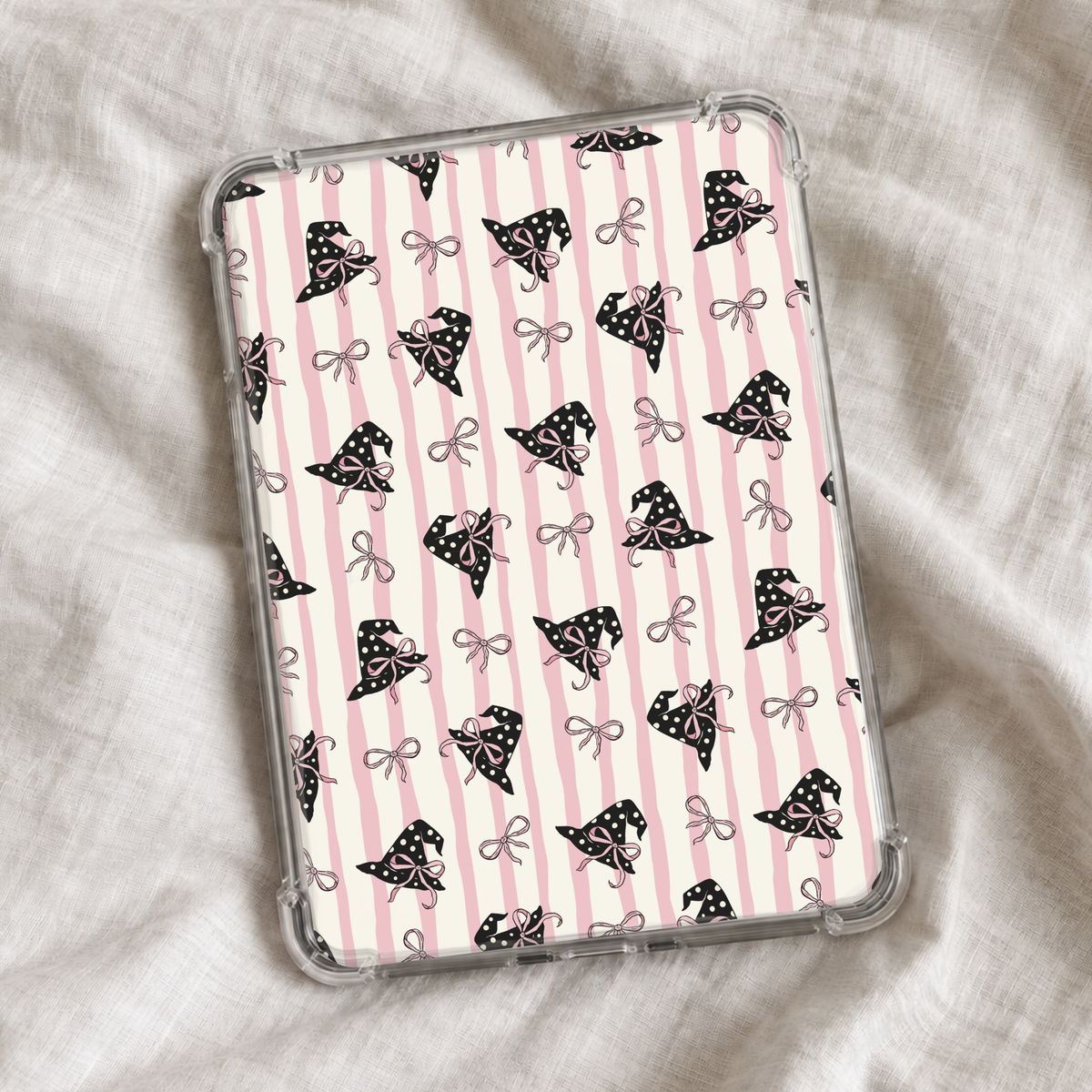 Girly Halloween Kindle insert featuring soft pink and cream vertical stripes with black polka-dot witch hats decorated with pink bows and scattered dainty bow details.